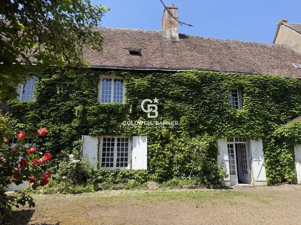Façade du prieuré du XIIe siècle habillée de vigne vierge, à vendre à proximité du Mans en Sarthe.