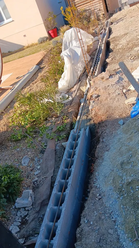 Démolition d'un ancien mur pour construire un mur de clôture