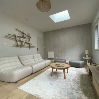 Salon lumineux avec canapé Cinna et table Ethnicraft, ambiance épurée et végétale, par l’Atelier D, architecte d'intérieur à Bordeaux