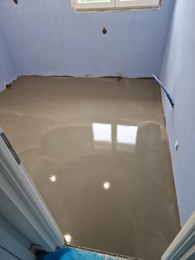Réalisation d’un ragréage de sol avant pose de carrelage dans une salle de bain en rénovation à Lyon
