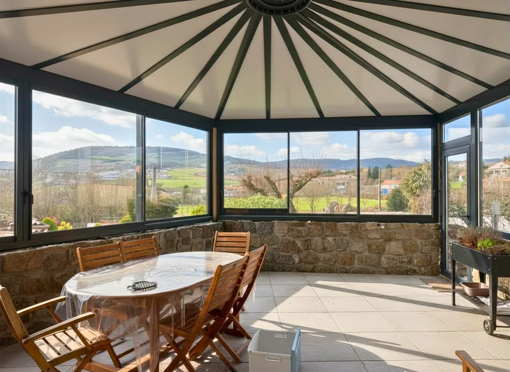 Conception et pose d'une veranda sur-mesure en alu avec toiture rayonnante et panneaux Thermotop à Peaugres en Ardèche
