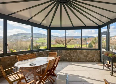 Conception et pose d'une veranda sur-mesure en alu avec toiture rayonnante et panneaux Thermotop à Peaugres en Ardèche