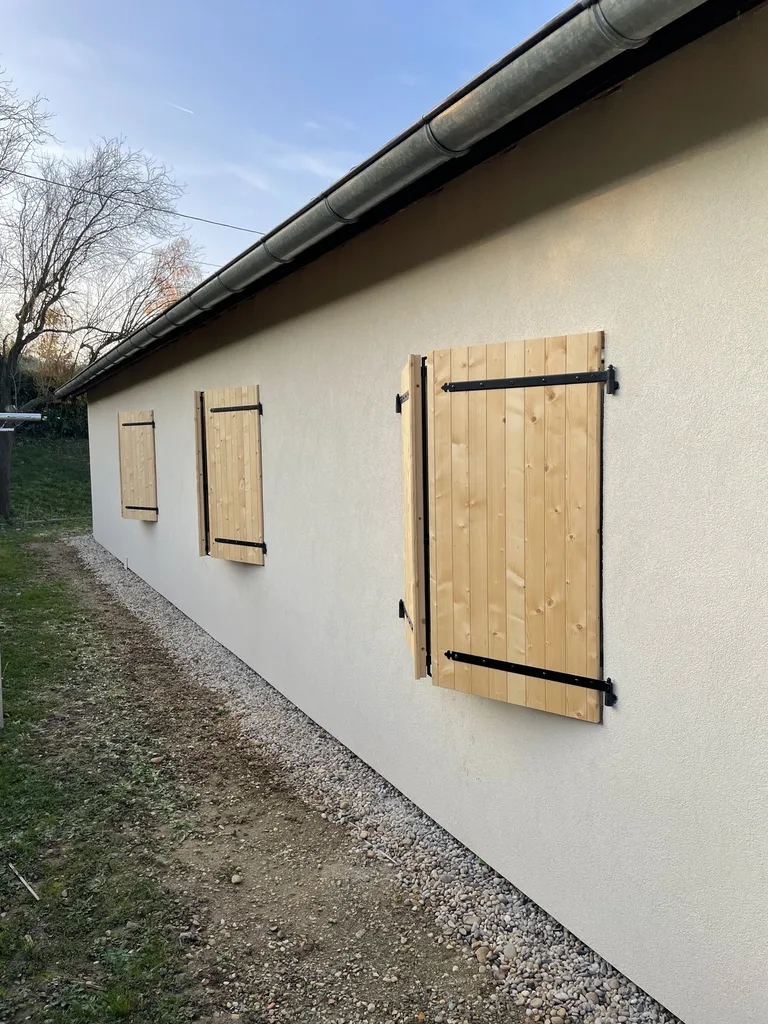 Façade après isolation thermique extérieure à Villefranche-sur-Saône avec enduit et volets bois pour améliorer le confort thermique