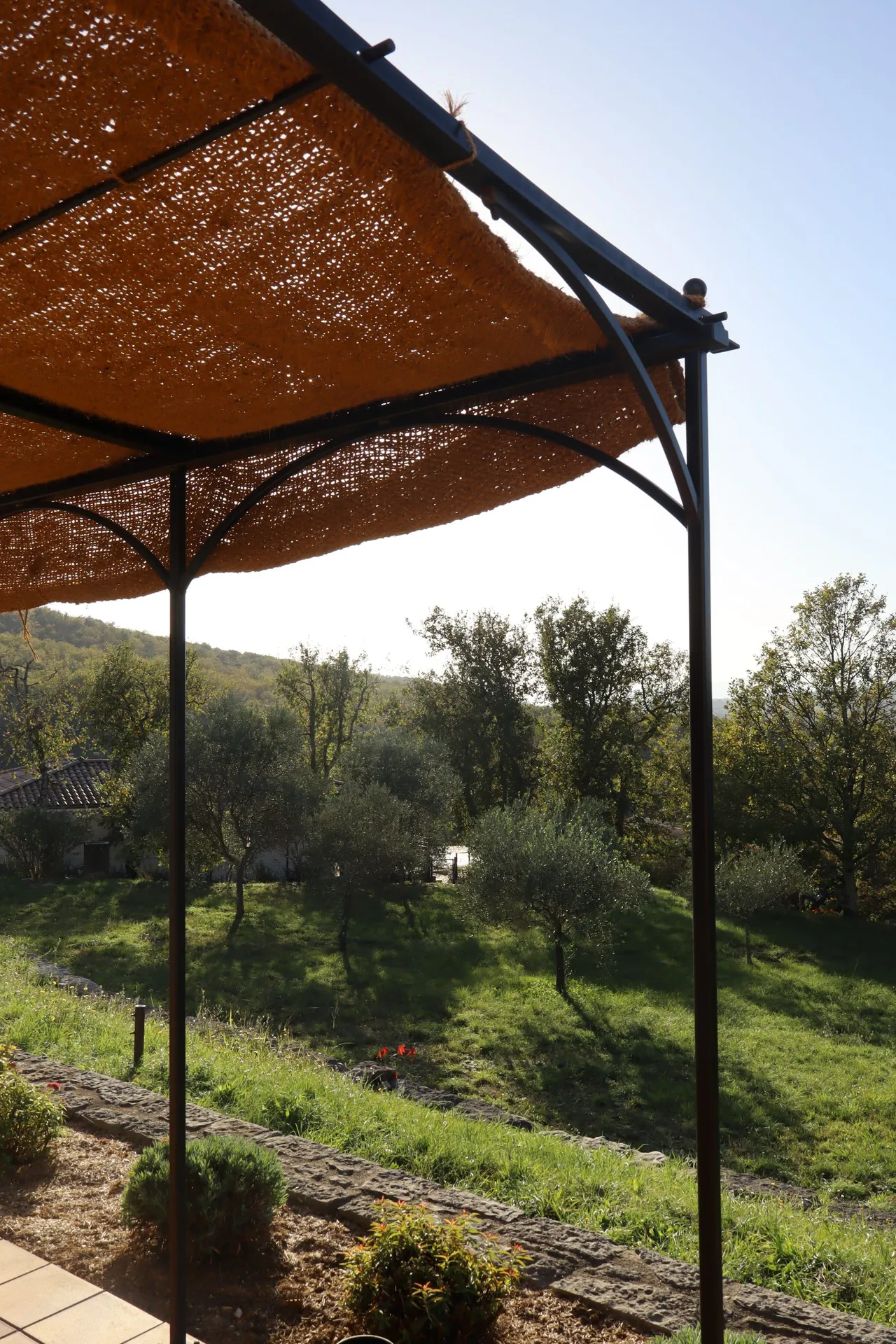 Pergola en fer forgé avec une toile de jute à Pradons en Ardèche pour l'été.