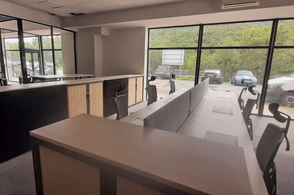 Aménagement de 270 m² de bureaux pour 32 postes à Brignoles avec mobilier ergonomique Made in France, gestion des câbles, acoustique optimisée et identité rouge-noir-bois