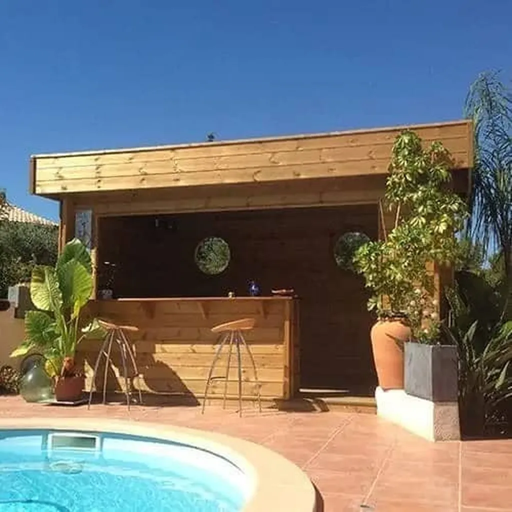 Pool house bois contemporain de 12 m² avec bar extérieur et espace convivial autour piscine à Sète à côté de Frontignan