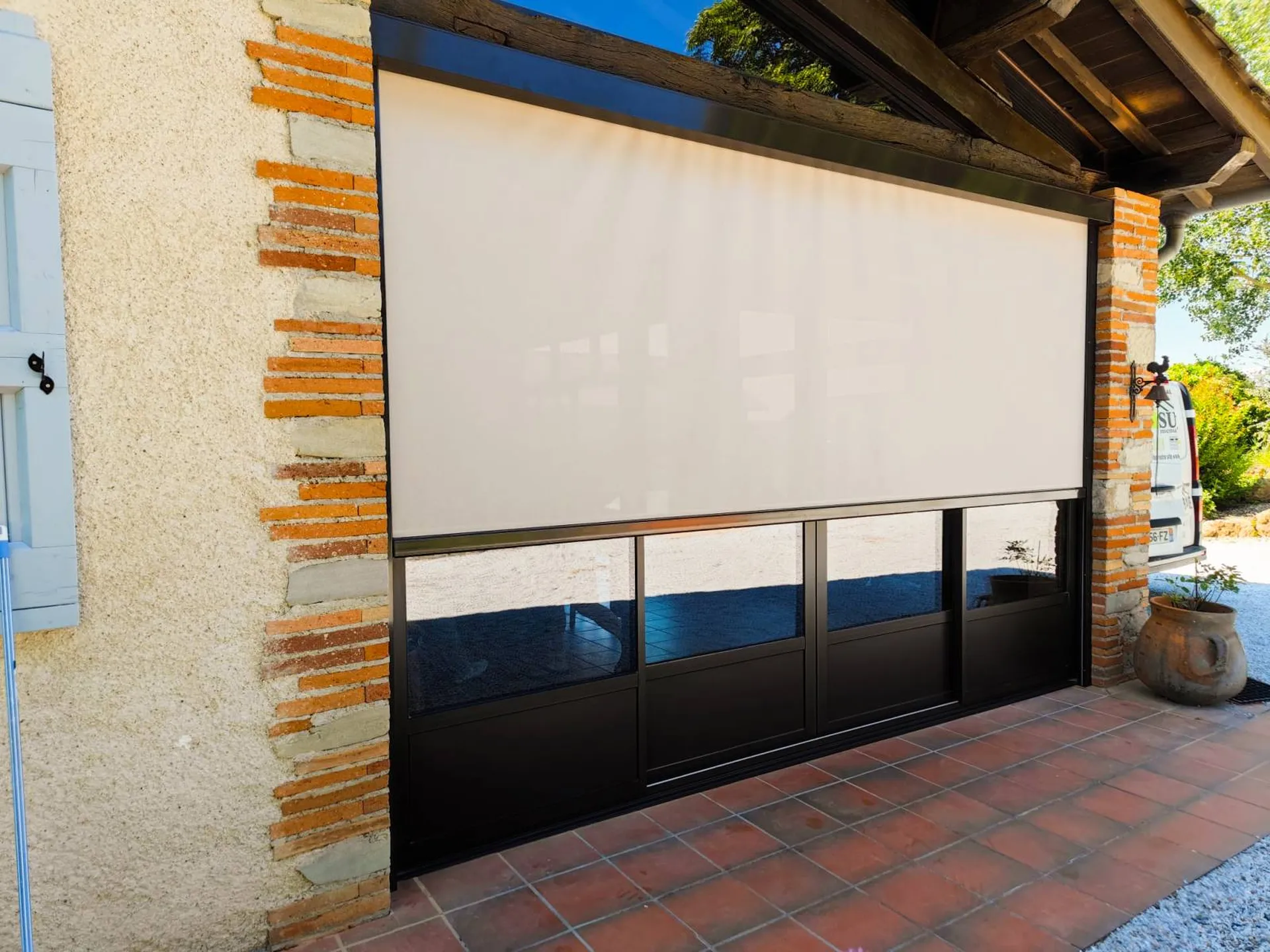 Installation d'un store zip motorisé blanc sur une fermeture de terrasse