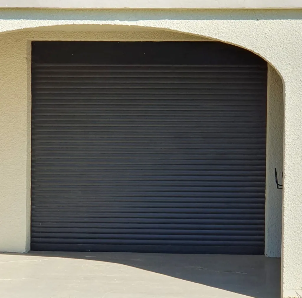 Porte de garage enroulable compacte sur-mesure motorisée LAKAL coloris gris anthracite avec manœuvre de secours à Cailloux-sur-Fontaine dans le Rhône (69)