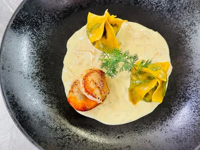 Ravioles de pousses d'épinards, noix de Saint-Jacques snackées dans une crème de moules.
