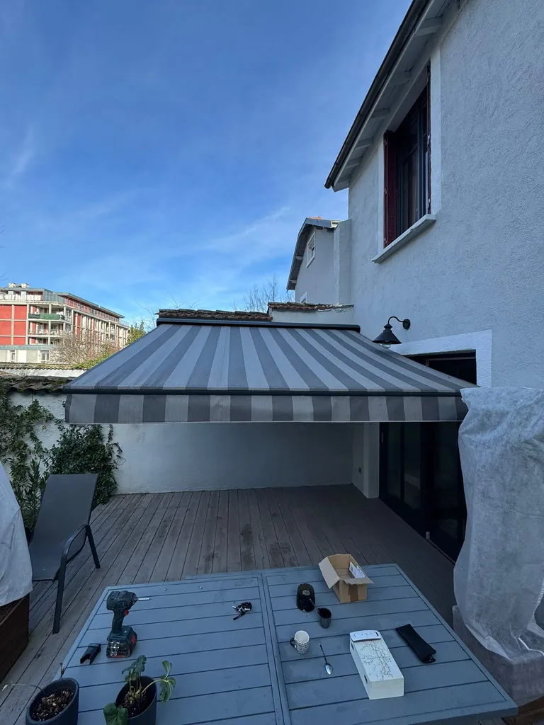 Pose d’un store Franciaflex motorisé sur mesure au-dessus d'une terrasse de maison dans un petit espace à Villeurbanne