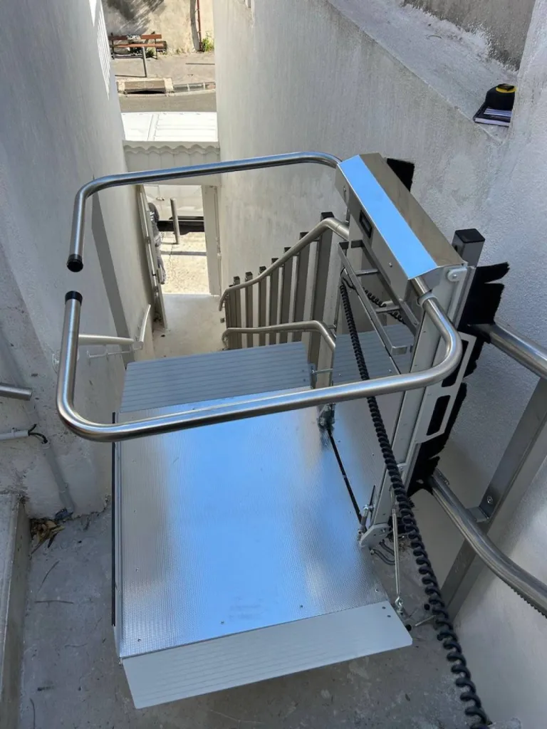 Les bras de la plateforme contribuent à la sécurité des passagers de cette plateforme oblique Lehner Stratos en extérieur dans un escalier droit avec palier intermédiaire à proximité de la mer à Marseille