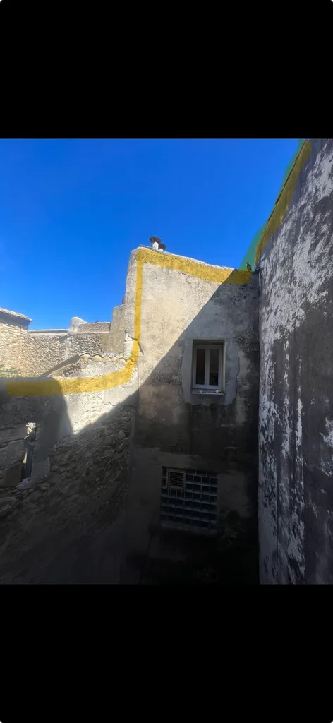 Pose de filet anti pigeon à l’intérieur d’une petite cour d’un immeuble de village qui se situe  à Pont-Saint-Esprit dans le Gard (30)