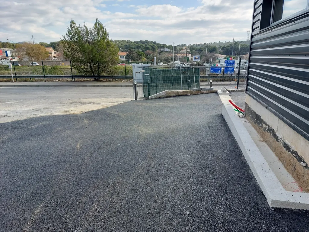 Réalisation du parking d'un entrepôt en enrobé de bitume noir à Septême les Vallons dans les Bouches du Rhône