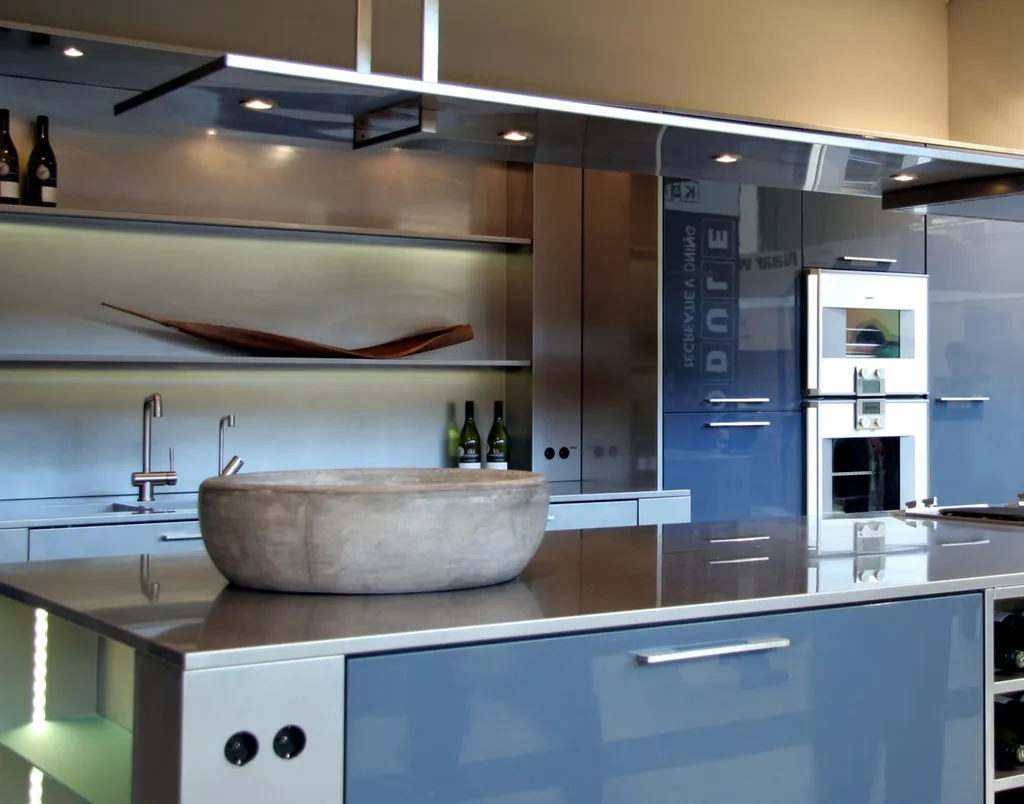 Plan de travail inox en îlot avec intégration des prises et hotte aspirante design assortie Antibes