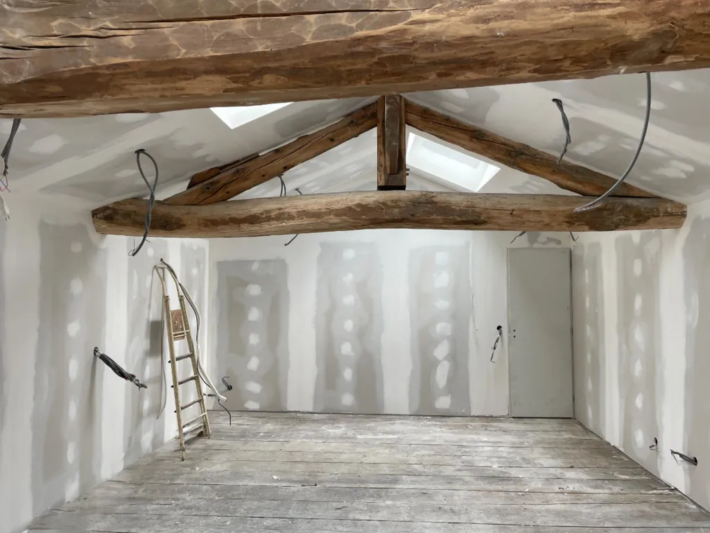 Travaux d'aménagement des combles en suite parentale dans une maison ancienne à Blacé (69) proche d'Arnas dans le Beaujolais avec poutres bois apparentes mises en valeur