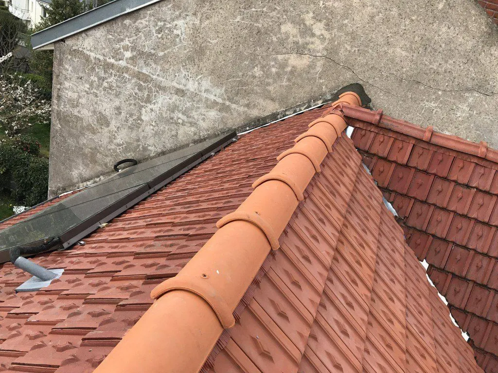 Pose de tuiles neuves lors d'une réfection de faîtage traditionnel sur une maison individuelle à Nantes