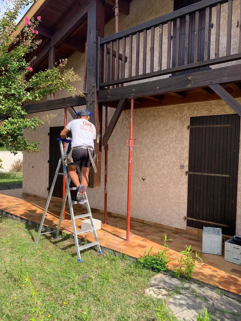 Installation d’un poteau en bois en soutien au balcon d’une maison située à Biscarrosse