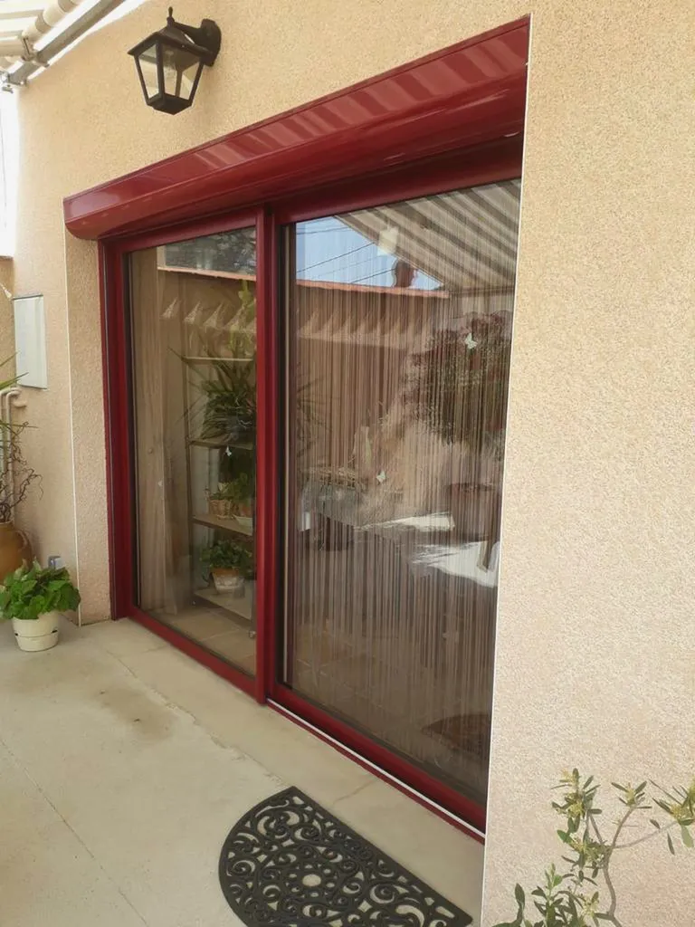 Installation baie coulissante 2 vantaux PVC/alu Bouvet intérieur blanc et extérieur rouge RAL 3004 avec volet roulant motorisé RAL 3004 à Valence (26)