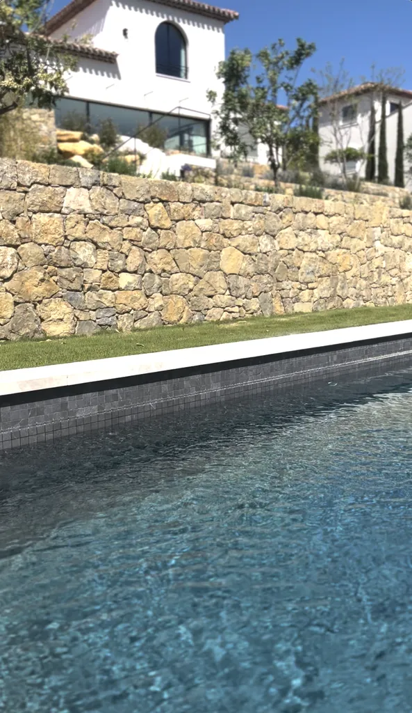 Margelle de piscine en pierre naturelle, conçue sur mesure pour un extérieur élégant et durable.