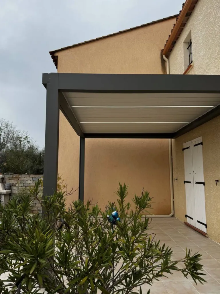 Pose d'un pergola à lames orientables adoccés à la façade et d'un store vertical