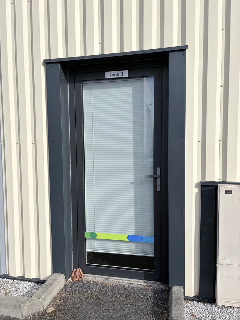 Pose d’une porte vitrée K-Line Grand Trafic gris anthracite RAL 9006 pour bâtiment professionnel à Rouffiac-Tolosan près Toulouse