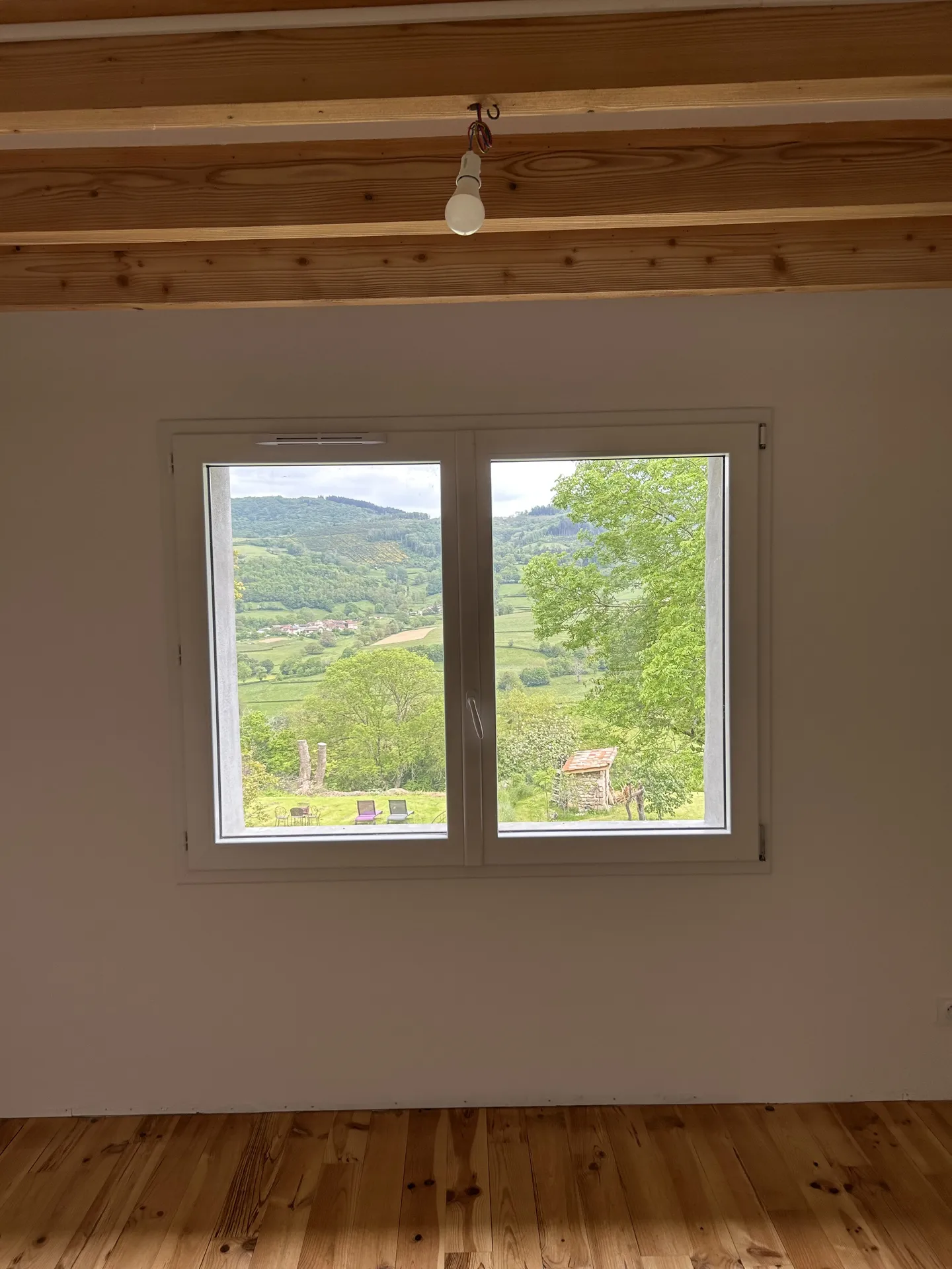 Nouvelle fenêtre après agrandissement dans un mur porteur permettant d’augmenter la luminosité et de valoriser une maison en pierre à Beaujeu (Rhône 69)
