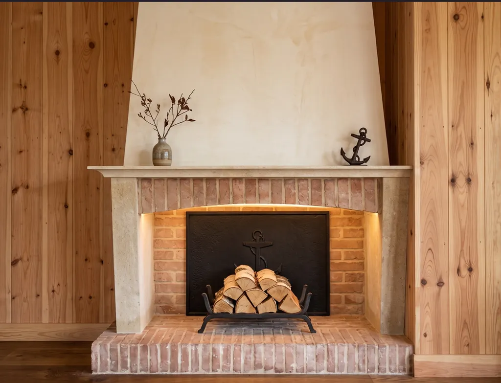 Pose d'une cheminée classique en pierres et en briquettes dans une maison au Cap Ferret