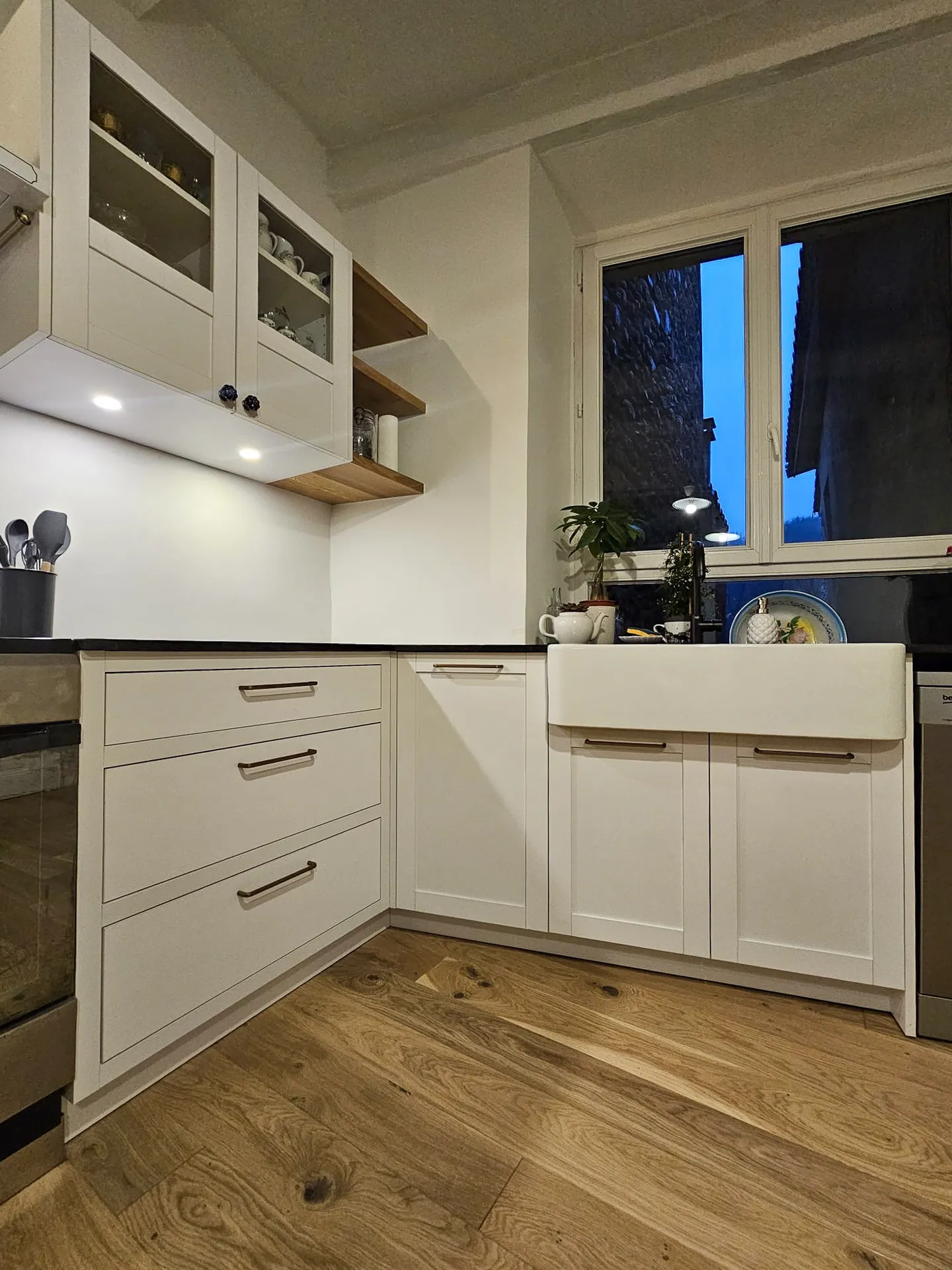Cuisine sur mesure blanche et chêne à Vogüé : agencement en L, évier timbre d’office et finitions soignées