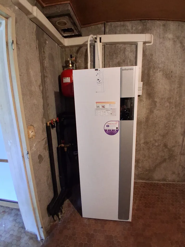 Artisan RGE en train de raccorder les circuits d'eau d'une installation de pompe à chaleur. Ener chauffage