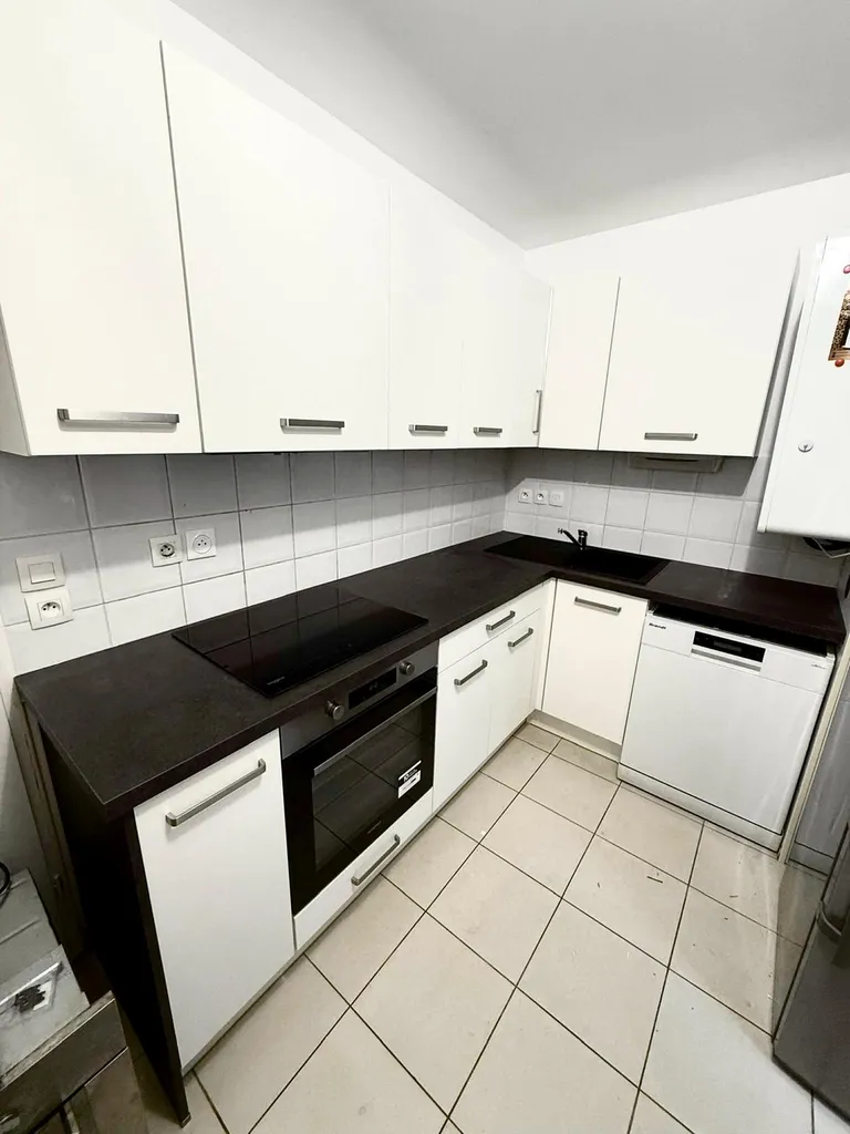 Cuisine équipée blanche et noire avec plan de travail en stratifié, poignées inox et meubles haut à Blagnac en Haute Garonne