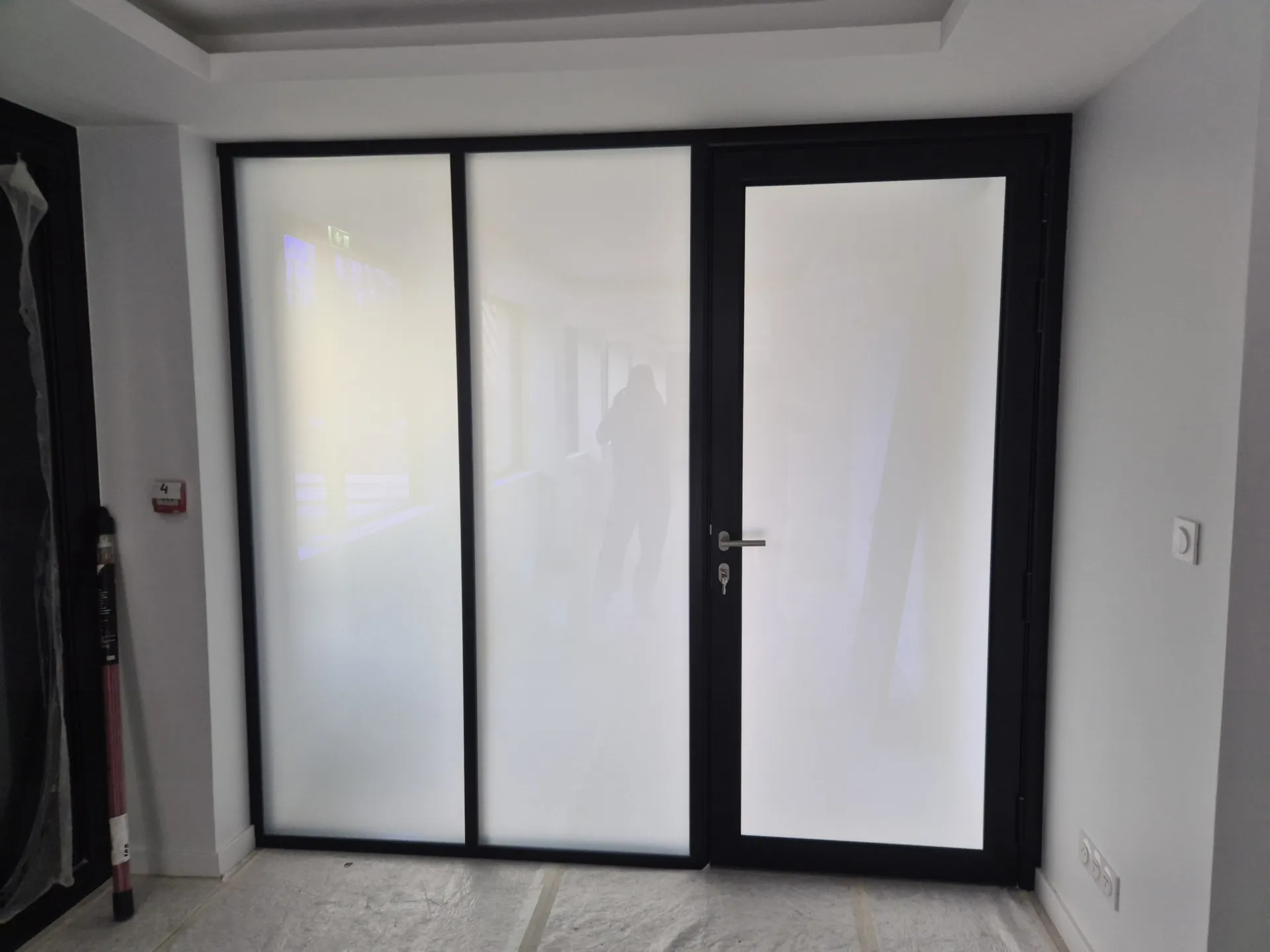 Pose de film opacifiant réglable sur les vitres des cloisons vitrées et les portes de bureau dans une entreprise à Limonest près de Lyon