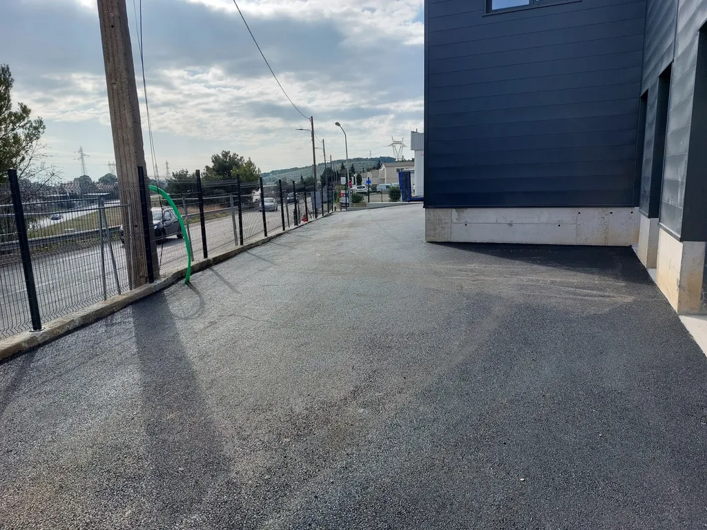 Réalisation du parking d'un entrepôt en enrobé de bitume noir à Septême les Vallons dans les Bouches du Rhône