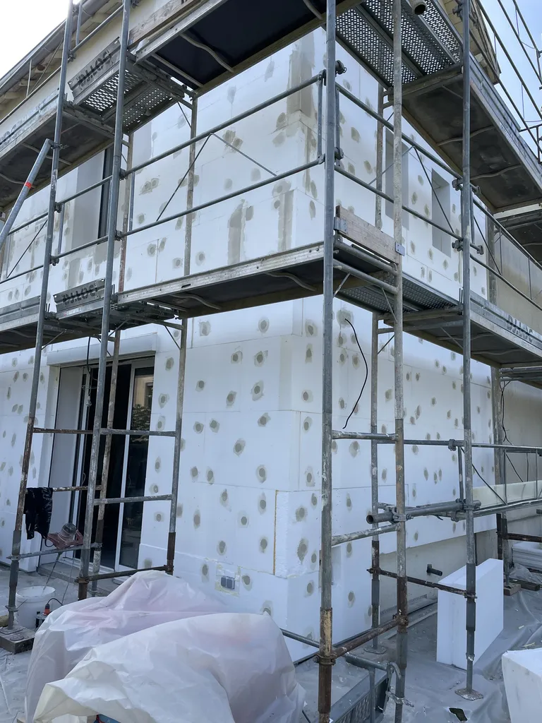 Fixation de l’isolant extérieur par chevillage sur façade lors de travaux d’isolation thermique par l’extérieur à Belleville-en-Beaujolais (Rhône 69)