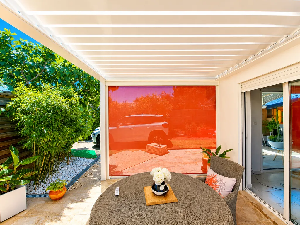 Le store ZIP corail apporte une touche moderne tout en améliorant le confort de cette terrasse.