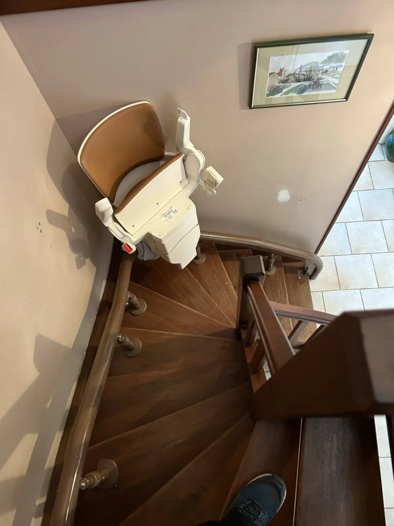 Le fauteuil monte escalier OTOLIFT Modul'Air Smart sur son point de charge dans l'escalier étroit 2/4 tournant en intérieur à Marseille