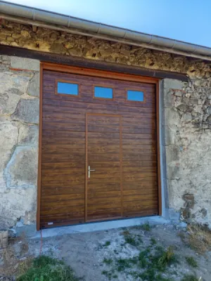 Pose d'une porte de garage sectionnelle GYPASS imitation bois avec portillon et 3 hublots sécurisés à St Pierre-du-Champ à côté d'Yssingeaux en Haute-Loire (43)