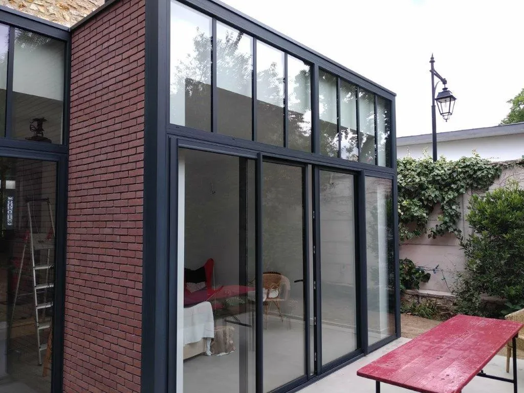 Installation d’une façade entièrement vitrée avec baies coulissantes et impostes à Sartrouville (78500) dans les Yvelines