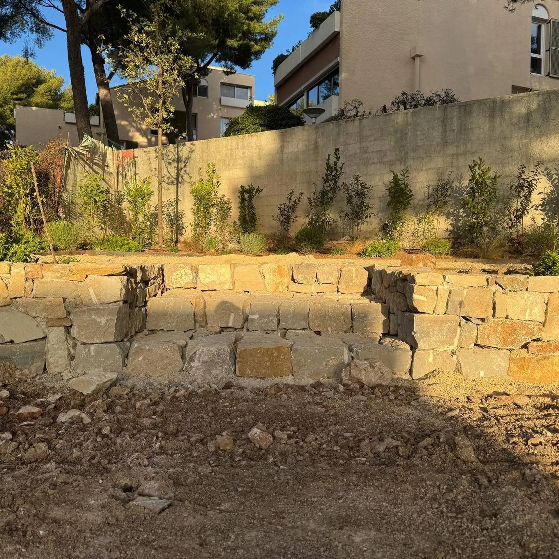 Un muret en pierre, construit par Carré Vert à Aix-en-Provence, 13090, pour un jardin à la fois structuré et élégant