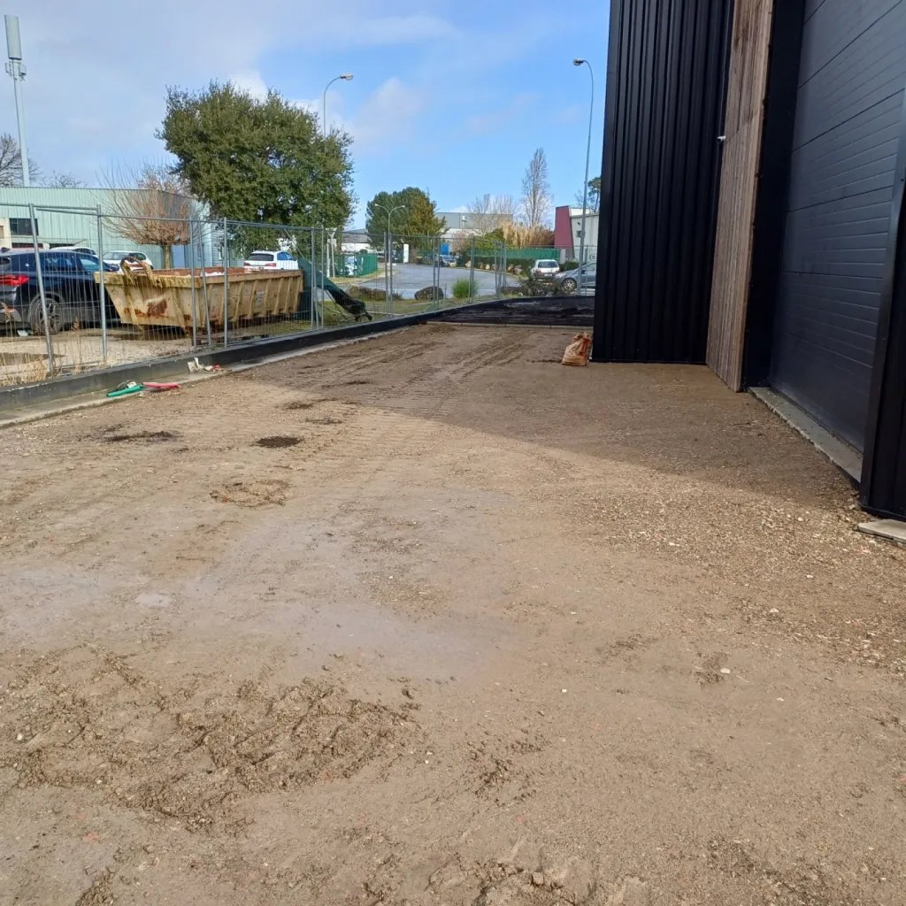 Création d’un parking de 780 m² sur la commune de Canéjan: réalisé autour d’un bâtiment industriel avec géotextile, concassé et bordures P1
