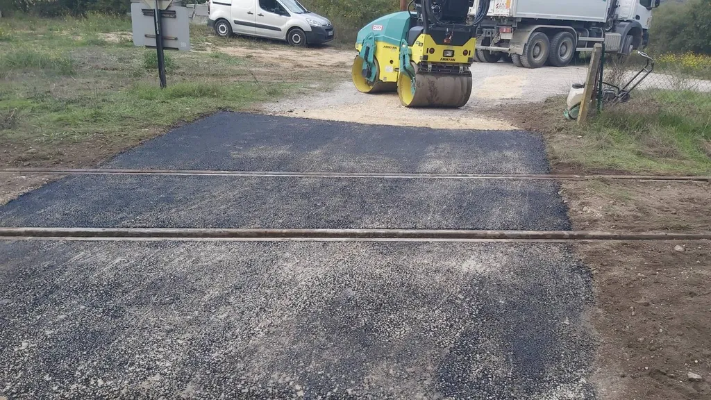 Remise en état d'un passage à niveau en enrobé de bitume noir à Meyreuil dans les Bouches du Rhône.