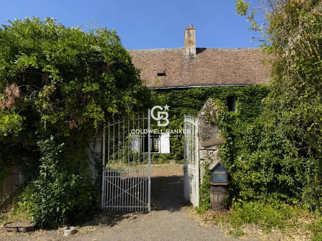 Portail en fer forgé envahi de glycine, entrée du parc de 2,4 hectares de cette propriété sarthoise.