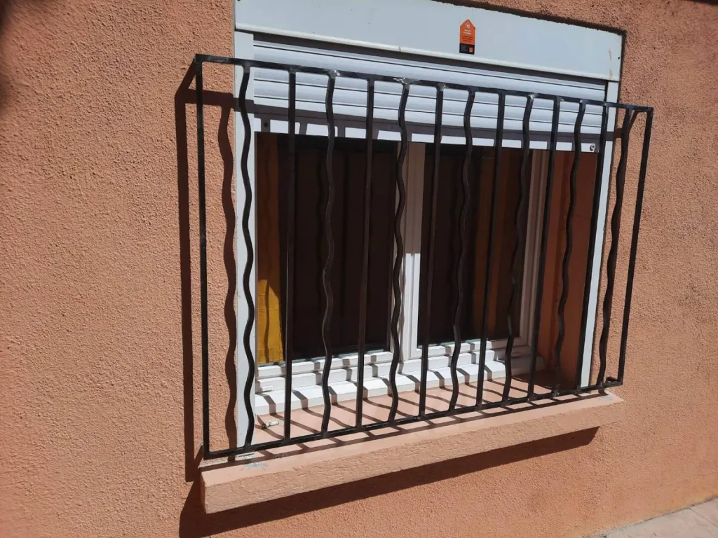 FABRICANT AVEC POSE DE GRILLE EN FER FORGE SUR MESURE BARREAUX DROITS ET ONDULES AVEC ESPACE POUR ACCES REPARATION VOLET ROULANT A MARTIGUES ET SES ALENTOURS 
