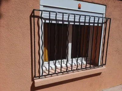 FABRICANT AVEC POSE DE GRILLE EN FER FORGE SUR MESURE BARREAUX DROITS ET ONDULES AVEC ESPACE POUR ACCES REPARATION VOLET ROULANT A MARTIGUES ET SES ALENTOURS 