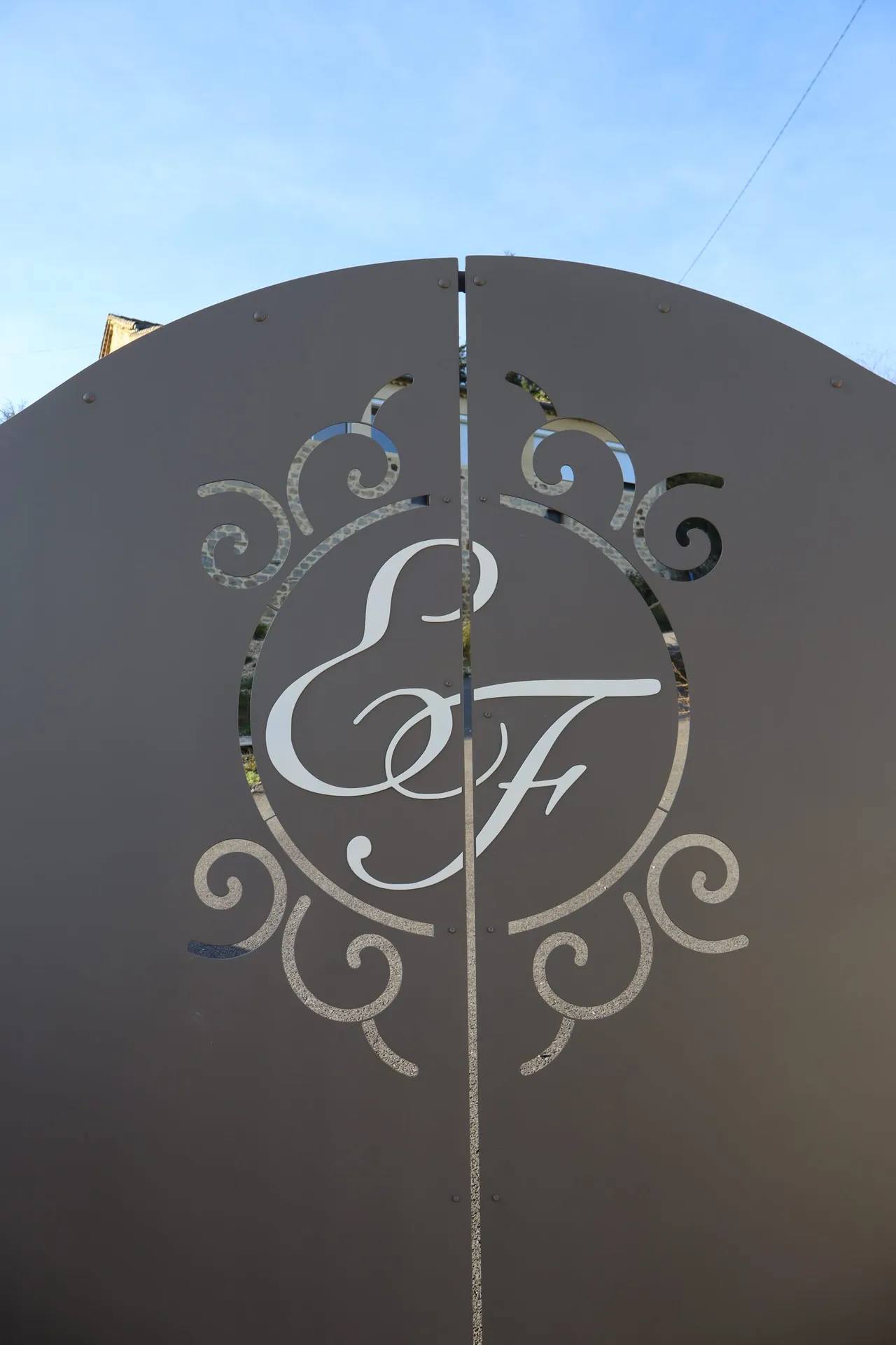 Portail en fer, avec initial incorporée au centre pour une entrée de propriété unique en Sud Ardèche.