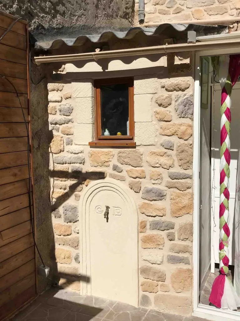 Décoration d'une façade en pierre  sur une maison de village à Bessan proche de Agde 