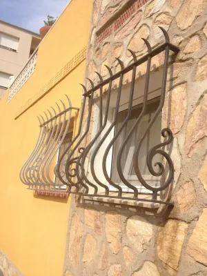 FABRICATION ET POSE GRILLE EN FER FORGE DE PROTECTION POUR  FENETRE A MARTIGUES BDR BARREAUDAGES BOMBES GALBES AVEC VOLUTES LATERALES