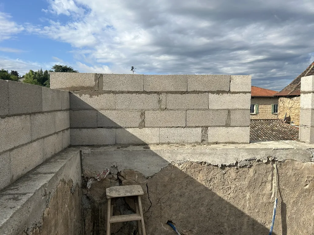 Montage de murs en moellons lors de travaux de maçonnerie dans le cadre d’une rénovation de maison à Anse (Rhône – 69).
