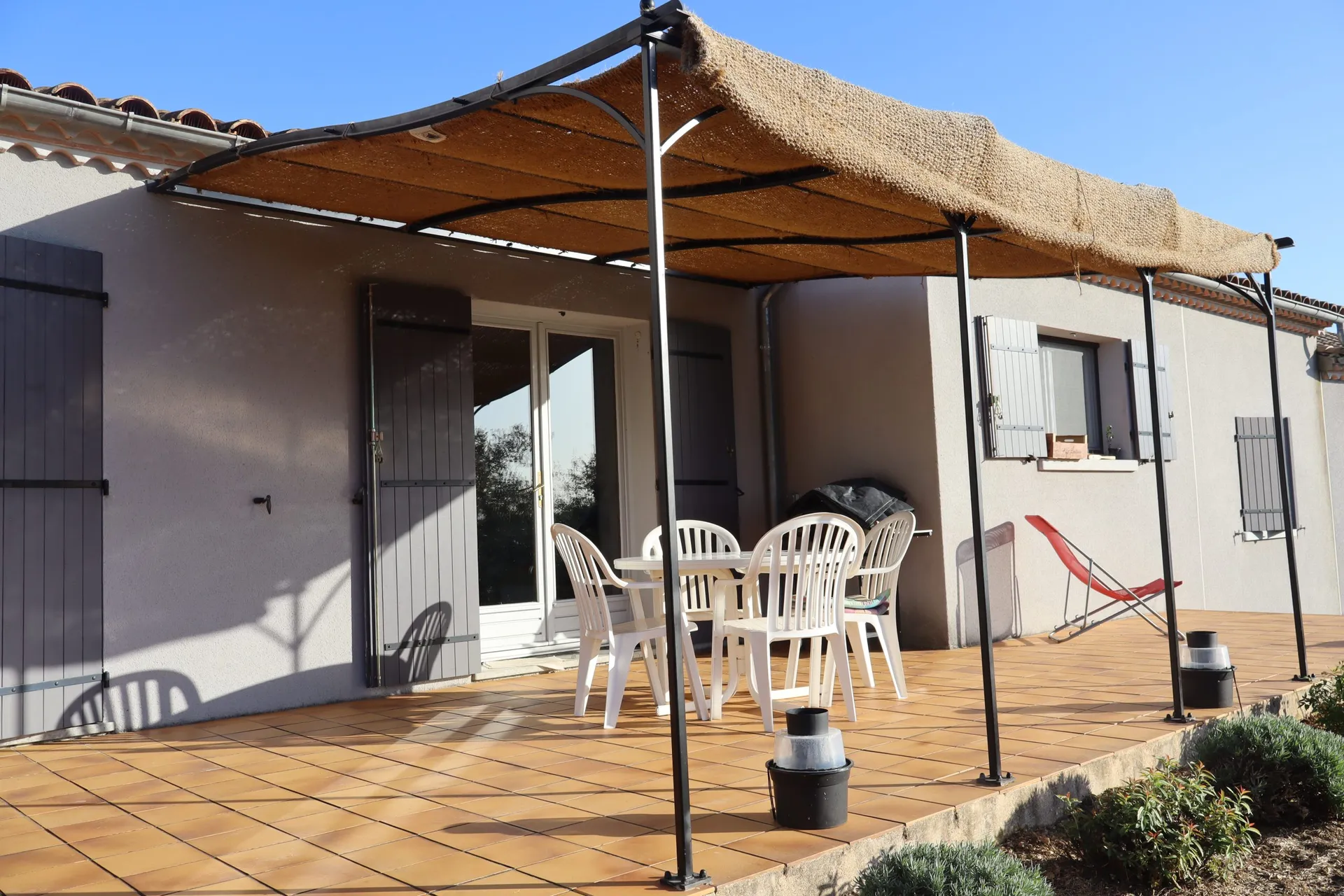 Pergola en fer forgé avec une toile de jute à Pradons en Ardèche pour l'été.