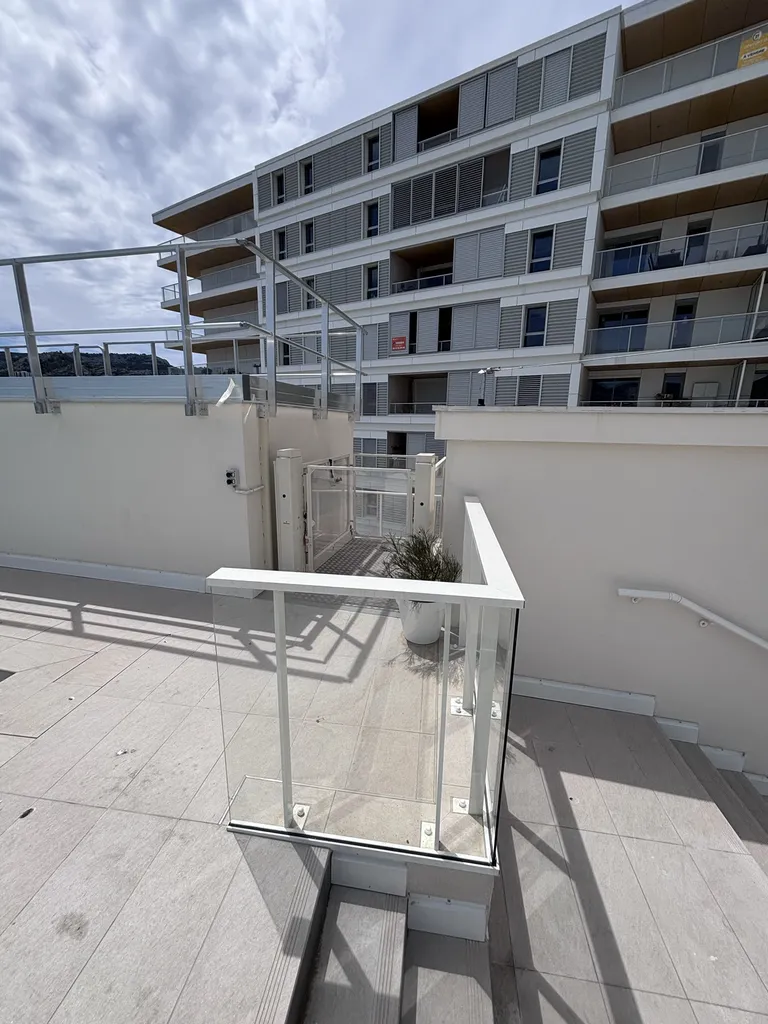 Sortie sécurisée pour les personnes en fauteuil sortant de la plateforme verticale Strategos pour accéder au toit terrasse d'un immeuble à Marseille