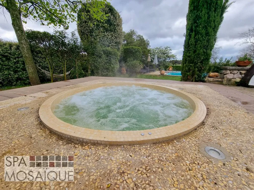 Un spa mosaïque carrelé encastré dans une terrasse en béton à Aix-en-Provence